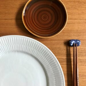 Brun soyaskål og blå spisepindeholder med mønster